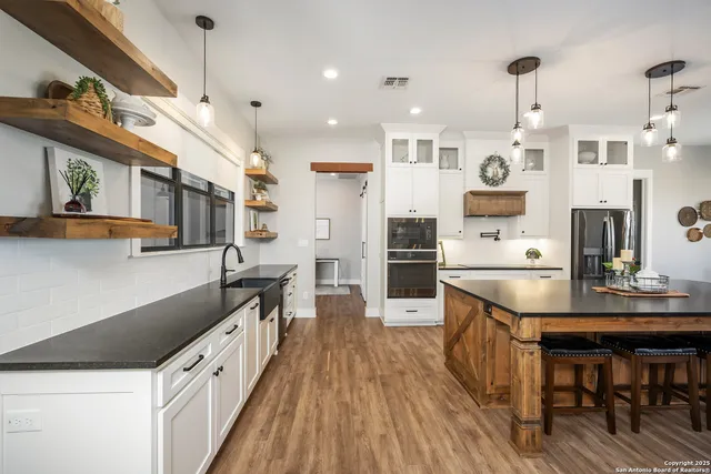 a kitchen with stainless steel appliances granite countertop a sink a stove and a refrigerator