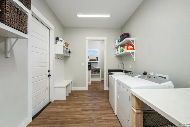 a spacious bedroom with a bed chandelier and a window