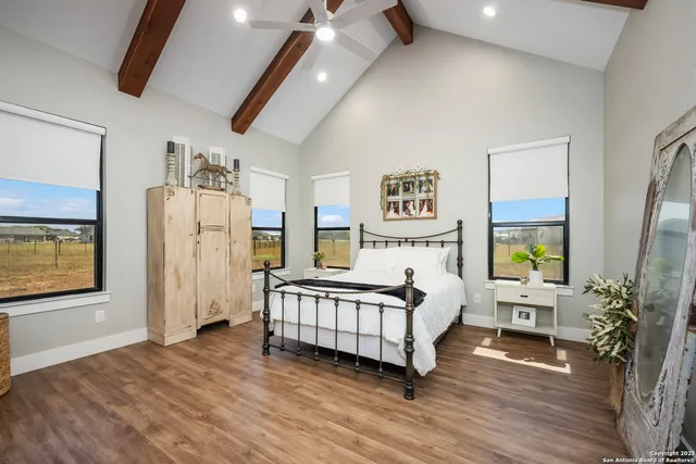 a bedroom with a bed and large windows