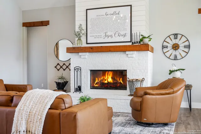 a living room with furniture a fireplace and a flat screen tv