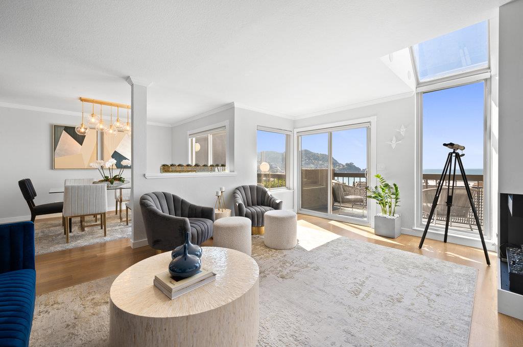 a living room with furniture a large window and kitchen view