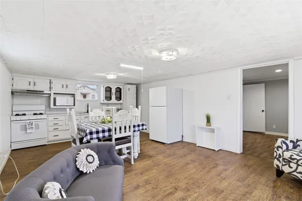 a living room with furniture and a dining table with kitchen view