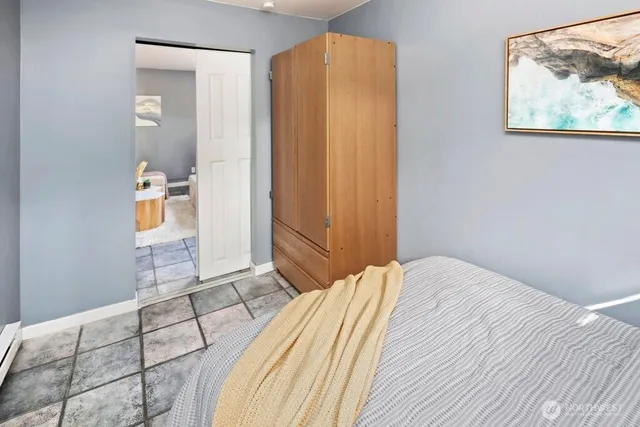 a bedroom with a bed and a painting on the wall