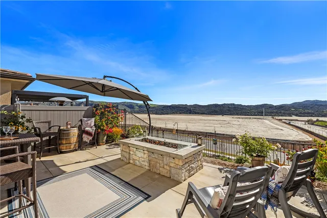 a view of a patio with lawn chairs under an umbrella