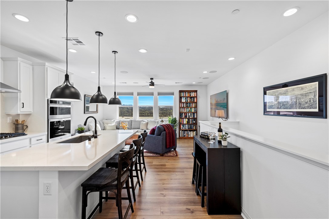 821 Cornelia Way Rancho Mission Viejo, CA 92694 - Photo 4 of 61 a kitchen with stainless steel appliances kitchen island granite countertop a stove a sink a dining table and chairs with wooden floor