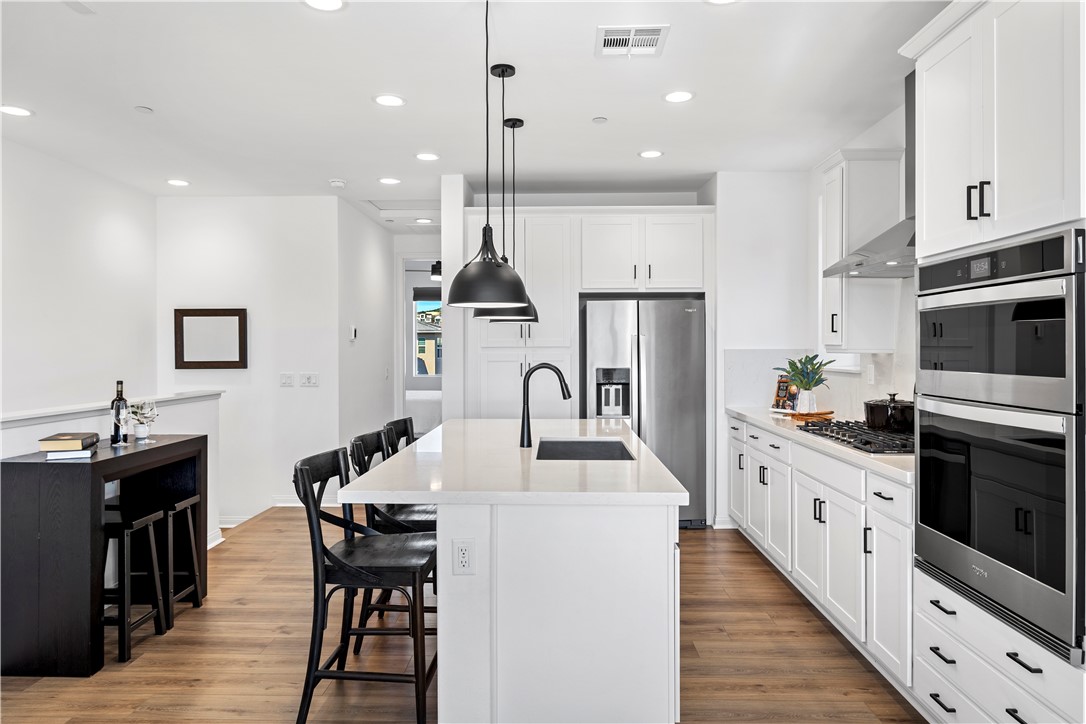 821 Cornelia Way Rancho Mission Viejo, CA 92694 - Photo 6 of 61 a kitchen with stainless steel appliances kitchen island granite countertop a sink a stove a dining table and chairs