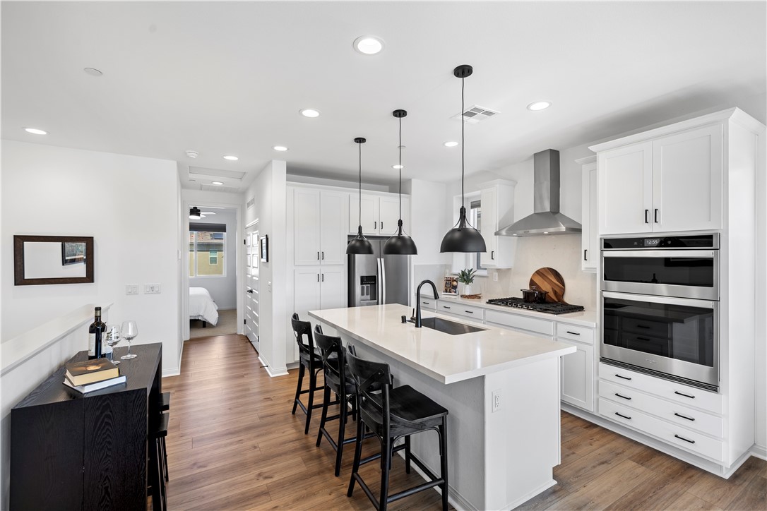 821 Cornelia Way Rancho Mission Viejo, CA 92694 - Photo 7 of 61 a kitchen with stainless steel appliances kitchen island a table chairs and a refrigerator