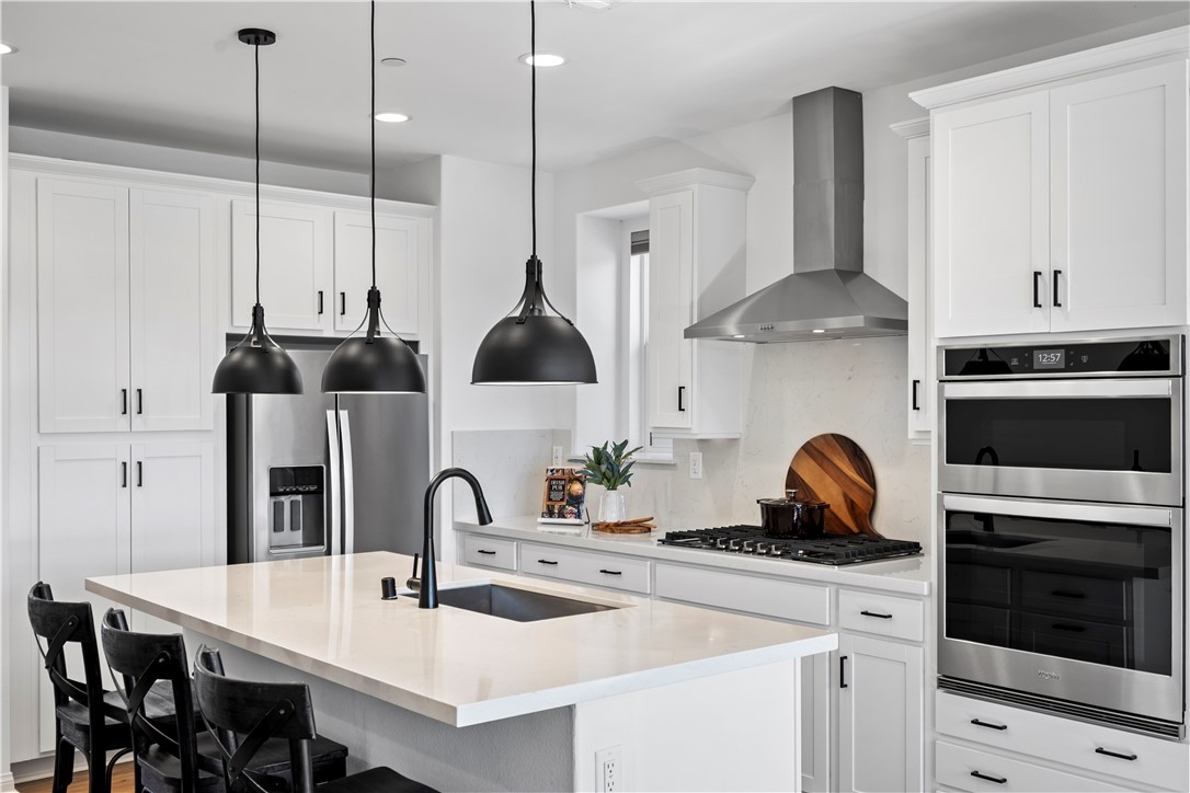 821 Cornelia Way Rancho Mission Viejo, CA 92694 - Photo 8 of 61 a kitchen with stainless steel appliances a stove a sink a oven and a dining table with wooden floor