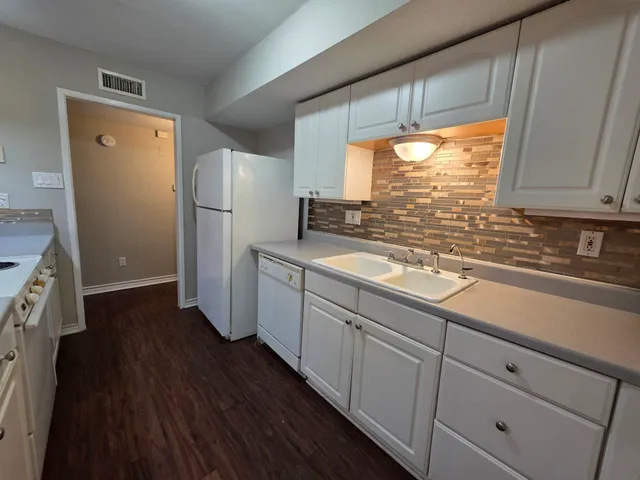 a kitchen with refrigerator cabinets and wooden floor