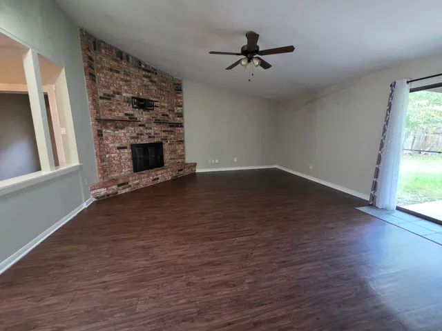 a view of a livingroom with wooden floor and a fireplace