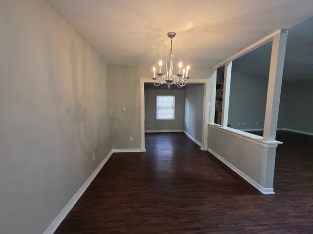 a view of a livingroom with wooden floor and chandelier