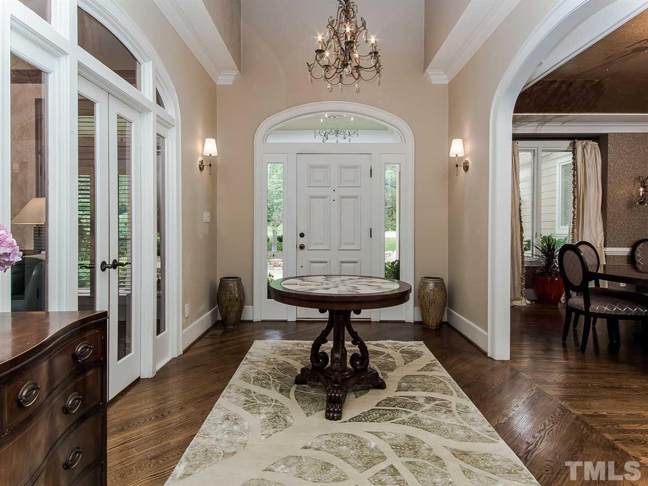 509 Lake Boone Trail Raleigh, NC 27608 - Photo 3 of 25 a view of a hallway that has a dining table and chandelier