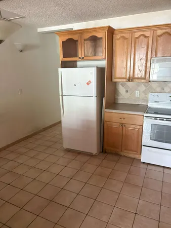a utility room with dryer washer and a view of kitchen