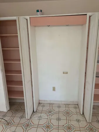 a view of walk in closet with empty racks
