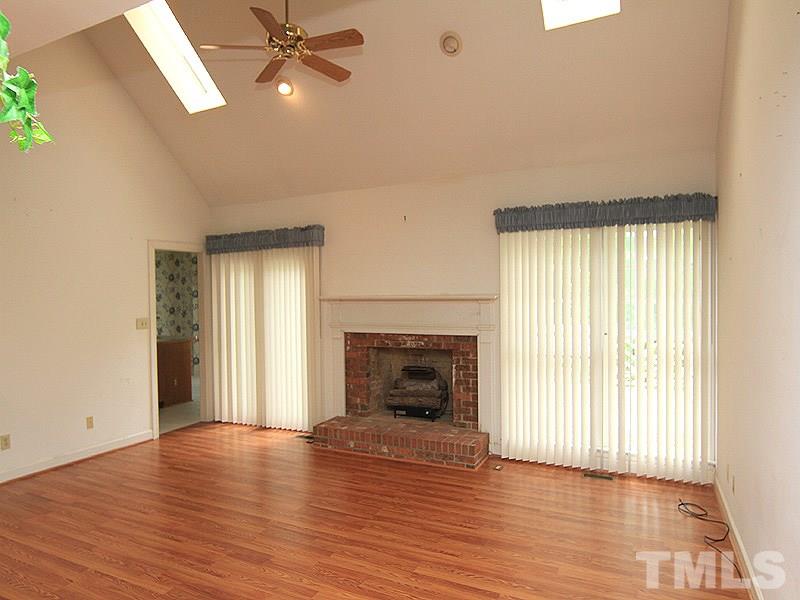 103 Calms Way Rougemont, NC 27572 - Photo 7 of 13 an empty room with wooden floor fireplace and windows