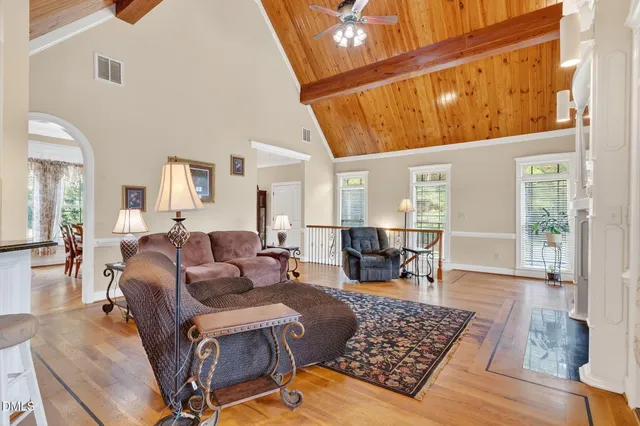 a kitchen with stainless steel appliances granite countertop a refrigerator a oven a sink a dining table and chairs with wooden floor