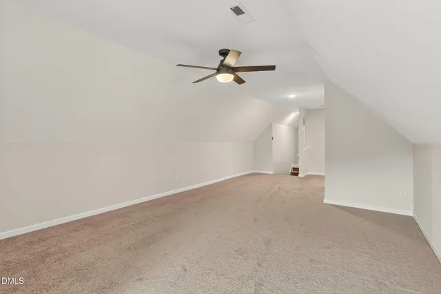 a view of a livingroom with furniture a ceiling fan and windows