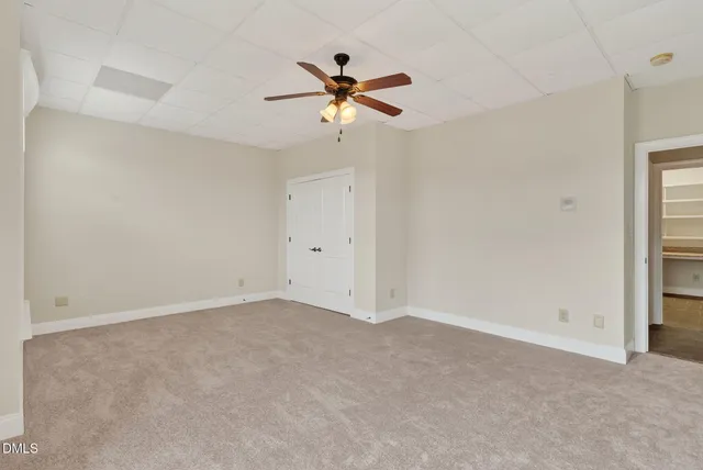a view of a house with large trees and a small yard