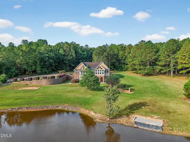 a view of a lake with a yard and outdoor seating