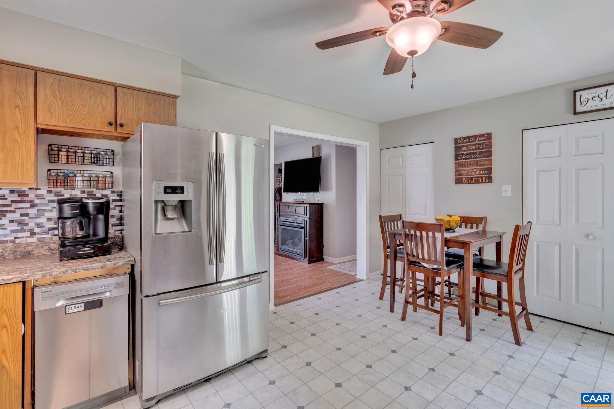2597 Ridge Road Palmyra, VA 22963 - Photo 14 of 28 a kitchen with stainless steel appliances kitchen island granite countertop a refrigerator a stove a microwave oven with a dining table and chairs