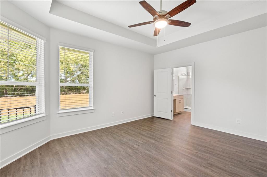 1012 Paddock Lane Georgetown, TX 78626 - Photo 5 of 15 A spacious primary bedroom features rich wood flooring and a refreshing ceiling fan.