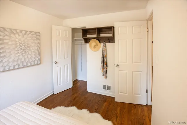 a view of a bedroom with wooden floor and closet