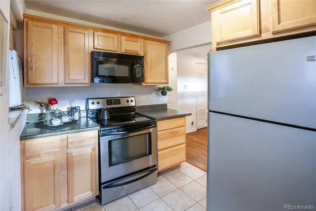 a kitchen with stainless steel appliances granite countertop a refrigerator and a stove top oven
