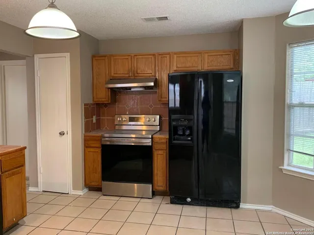 a kitchen with stainless steel appliances granite countertop a refrigerator and a stove