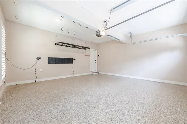 a view of a brick house with large windows and a yard with plants and large trees