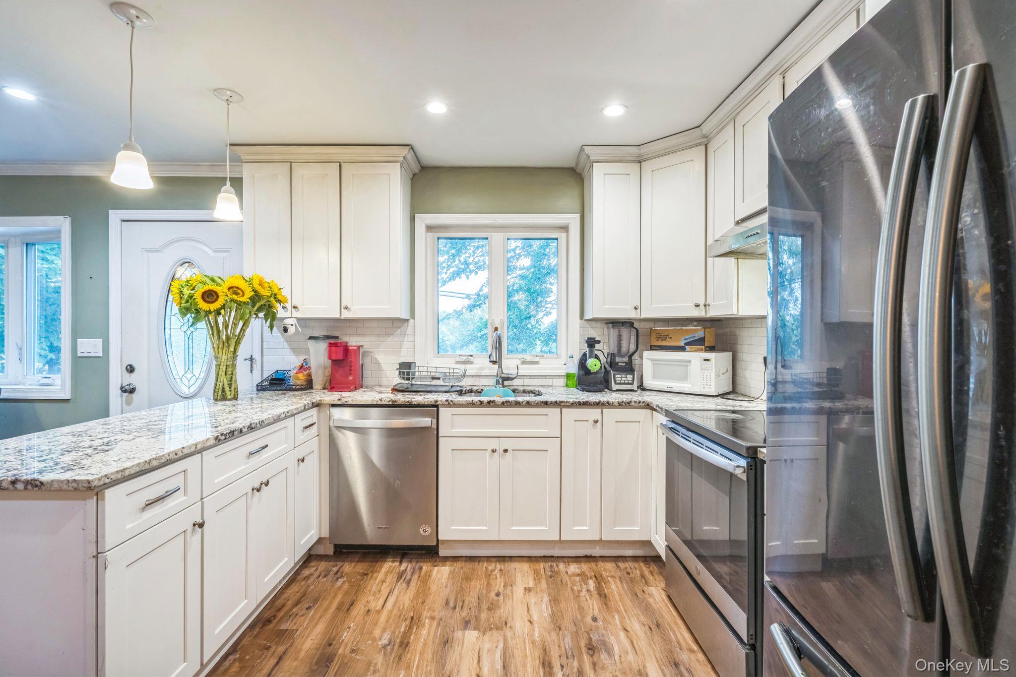 39 Willow Road Rocky Point, NY 11778 - Photo 11 of 18 Kitchen with stainless steel appliances, a peninsula, light wood-style flooring, tasteful backsplash, and recessed lighting