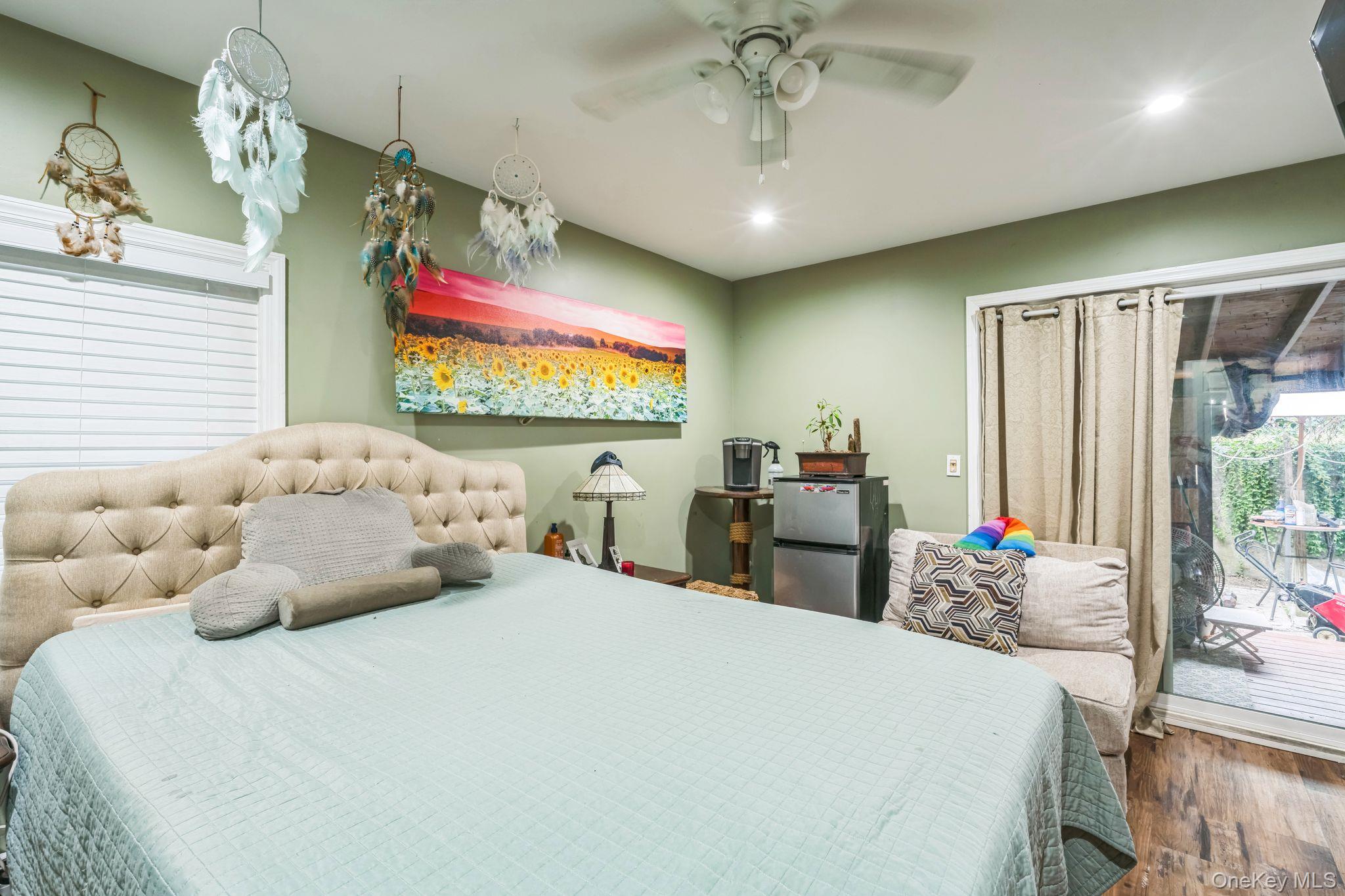 39 Willow Road Rocky Point, NY 11778 - Photo 13 of 18 Bedroom featuring access to outside, wood finished floors, recessed lighting, freestanding refrigerator, and ceiling fan