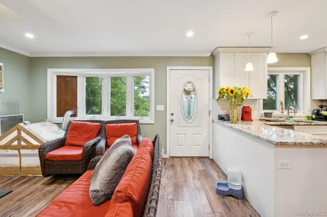 a living room with furniture a flat screen tv and a table