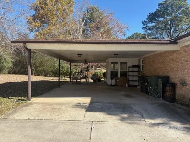 a living room with kitchen island granite countertop wooden floors and stainless steel appliances