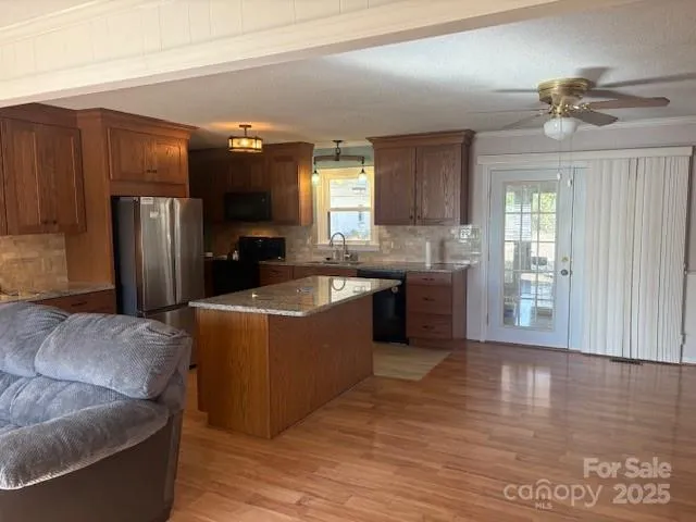 a living room with couches and kitchen view with wooden floor