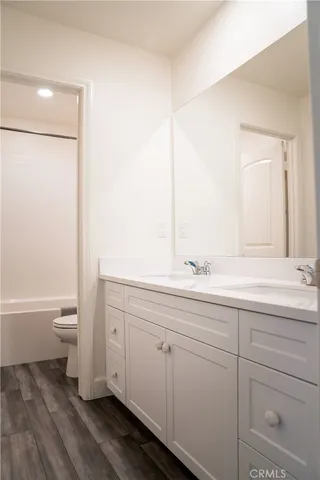 a view of a room with wooden floor and a ceiling fan