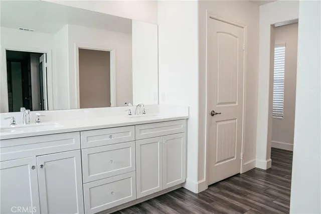 a view of a room with wooden floor and a ceiling fan