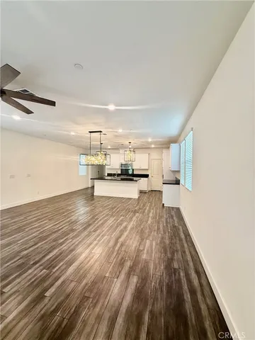 a large kitchen with stainless steel appliances wooden floor and a counter top space