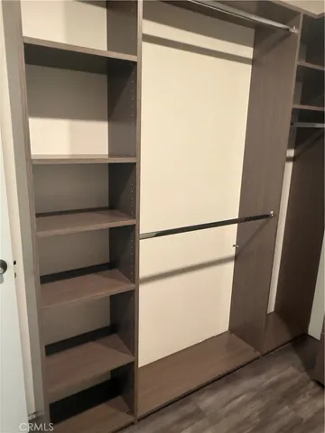 a view of walk in closet with empty racks