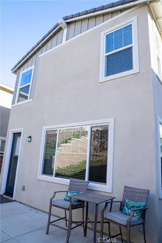 a view of a terrace with a floor to ceiling window and potted plants