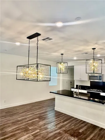 a kitchen with granite countertop white cabinets and black appliances