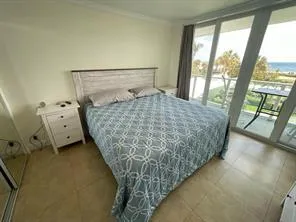 a bedroom with a bed and large windows