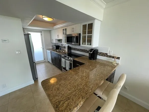 a kitchen with stainless steel appliances granite countertop a sink refrigerator and microwave