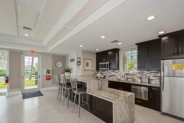a kitchen with stainless steel appliances kitchen island granite countertop a sink and cabinets