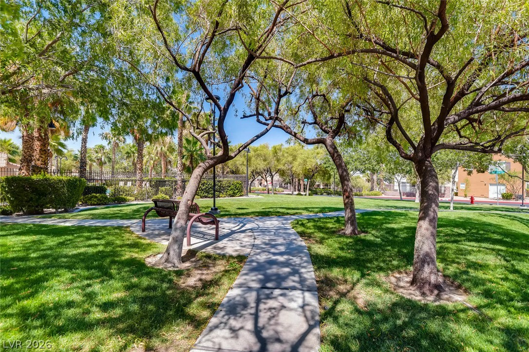 10451 Processor Court Las Vegas, NV 89129 - Photo 27 of 28 A tranquil green space with a walking path, shaded by mature trees.