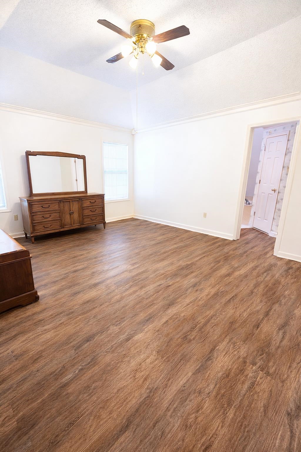 6708 Dawnhill Road Bartlett, TN 38135 - Photo 12 of 18 Spacious interior room featuring wood-finish flooring, white walls, and a vaulted ceiling with a brass-finish ceiling fan