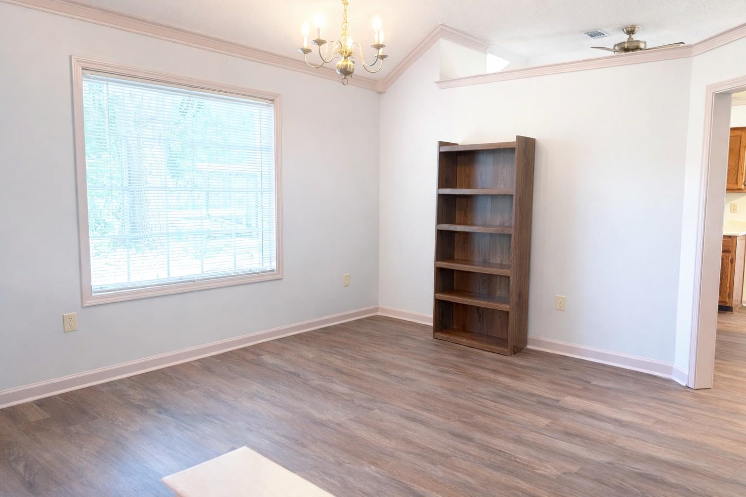 6708 Dawnhill Road Bartlett, TN 38135 - Photo 7 of 18 Spacious room featuring wood-finish flooring, a large window with blinds, and a distinctive vaulted ceiling