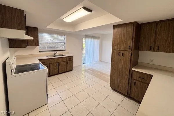 a kitchen with granite countertop a refrigerator and a stove top oven