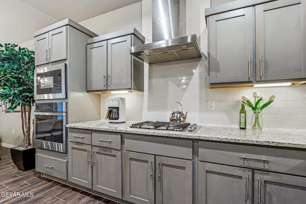a kitchen with stainless steel appliances granite countertop a sink a stove and cabinets