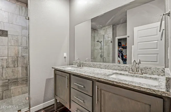 a bathroom with a granite countertop sink and a mirror
