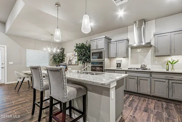 a kitchen with stainless steel appliances granite countertop a kitchen island a stove a table and chairs in it